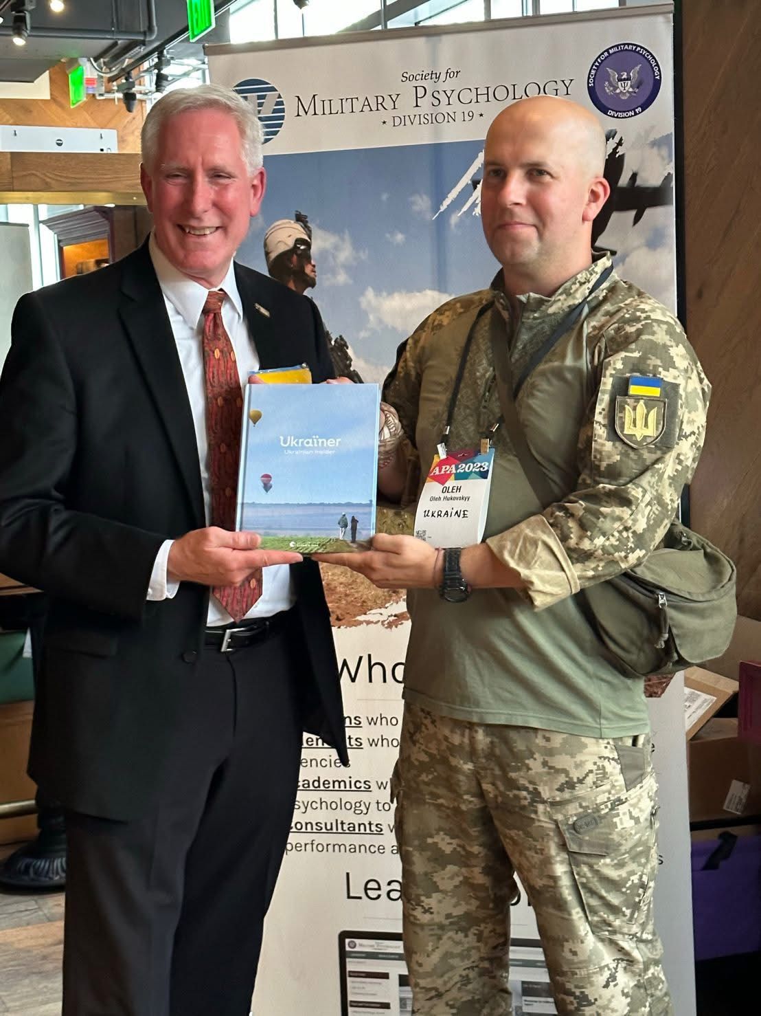 Ukrainian military psychologist exchanging materials with a US colleague at the APA Society for Military Psychology event